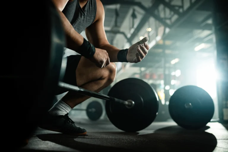 low-angle-view-unrecognizable-muscular-build-man-preparing-lifting-barbell-health-club copie